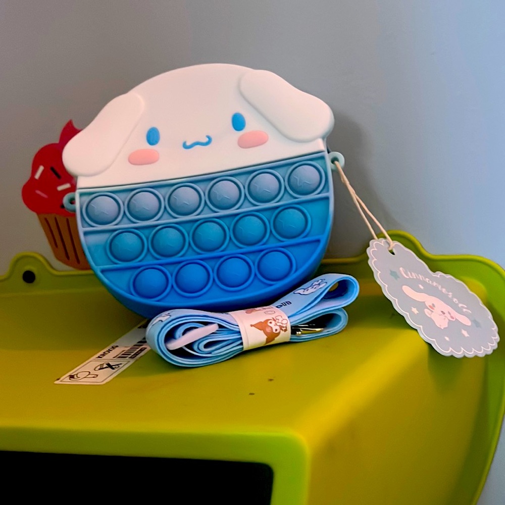 A Cinnamon Roll from Hello kitty friends is a crossbody pop it bag for girls.